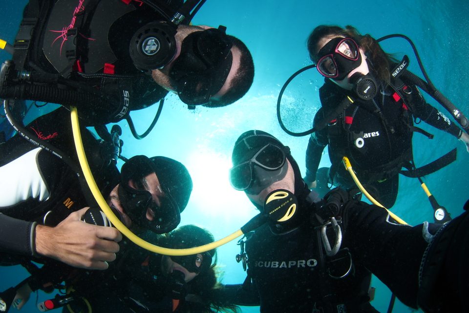 divemaster-course five divers on divemaster course taking a picture underwater
